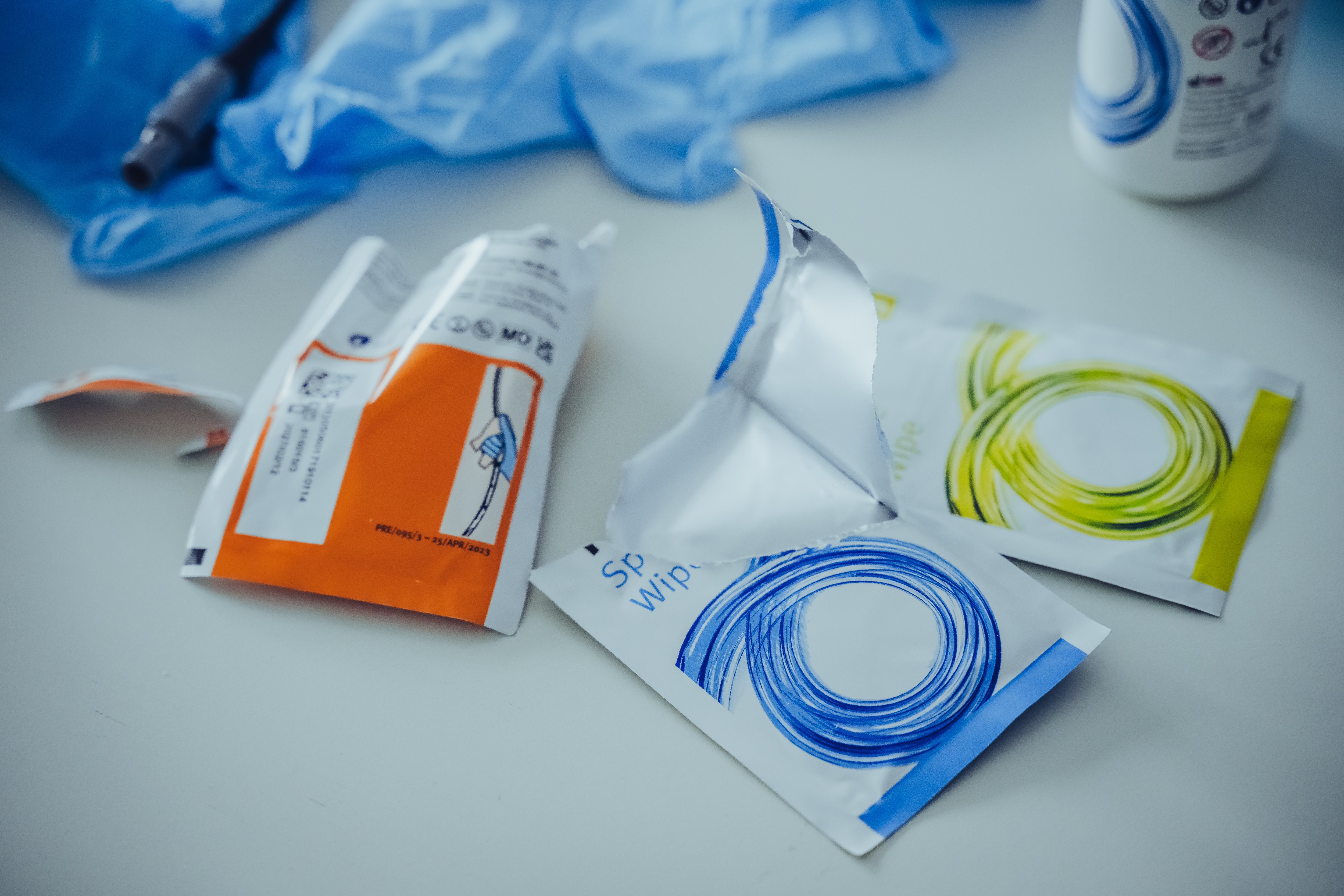 Medizinische Verpackungen und Desinfektionsmittel auf einer Arbeitsplatte.