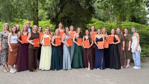 Abschlusskurs steht für ein Gruppenbild lächelnd zusammen