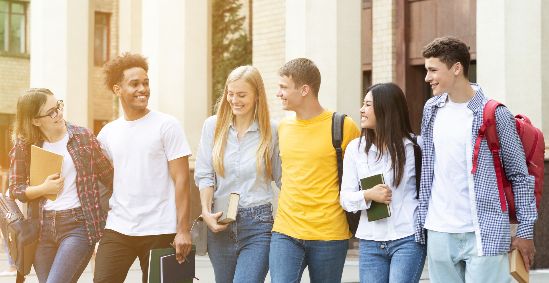 6 Jugendliche unterhalten sich und laufen gemeinsam über Campus