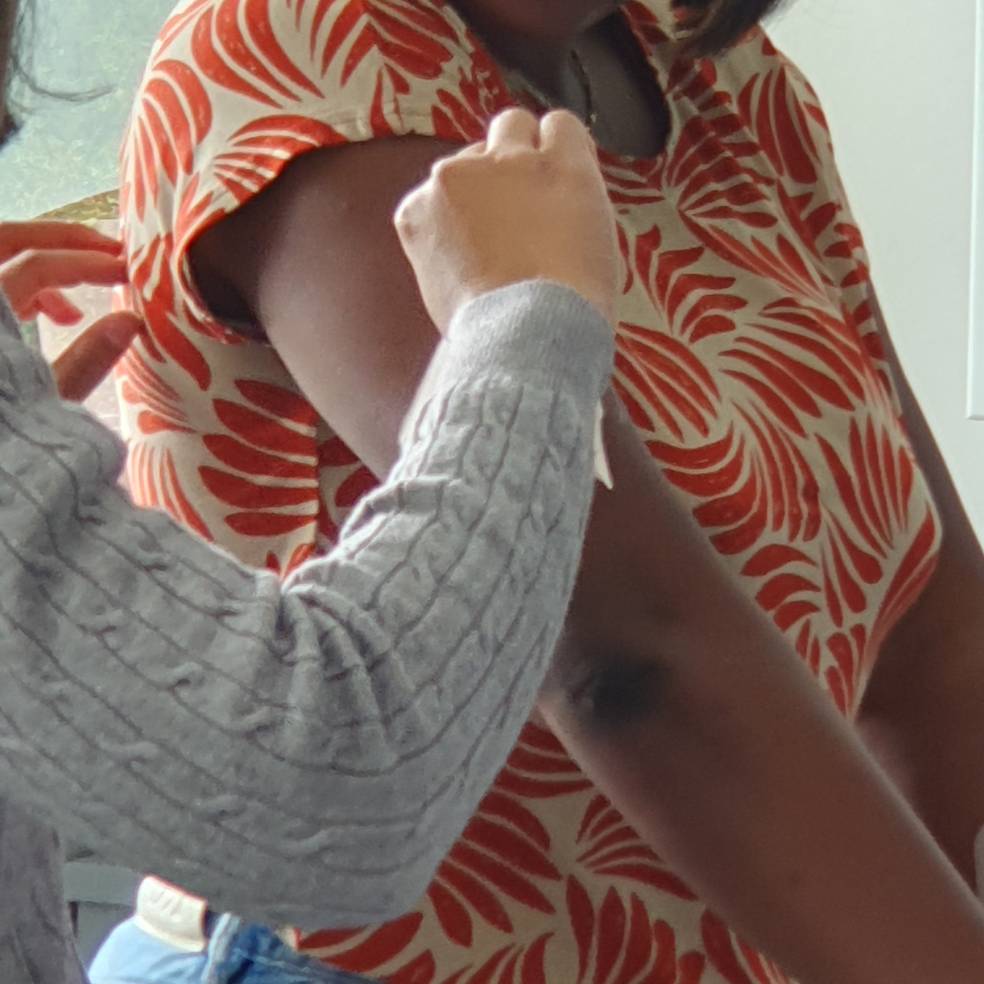 Nahaufnahme des Arms einer Schülerin samt Pflaster