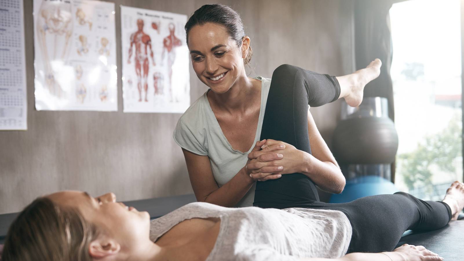 Physiotherapeutin behandelt Patientin an ihrem Bein