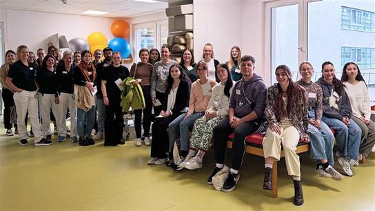 Eine Gruppe von Menschen posiert für ein Gruppenfoto in einem Raum.