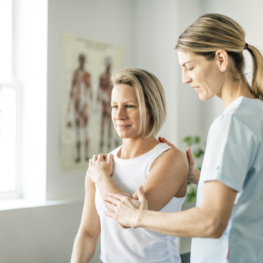 Physiotherapeutin behandelt Patientin an der Schulter