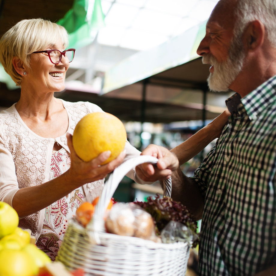 Zwei ältere Menschen kauen Früchte auf dem Markt